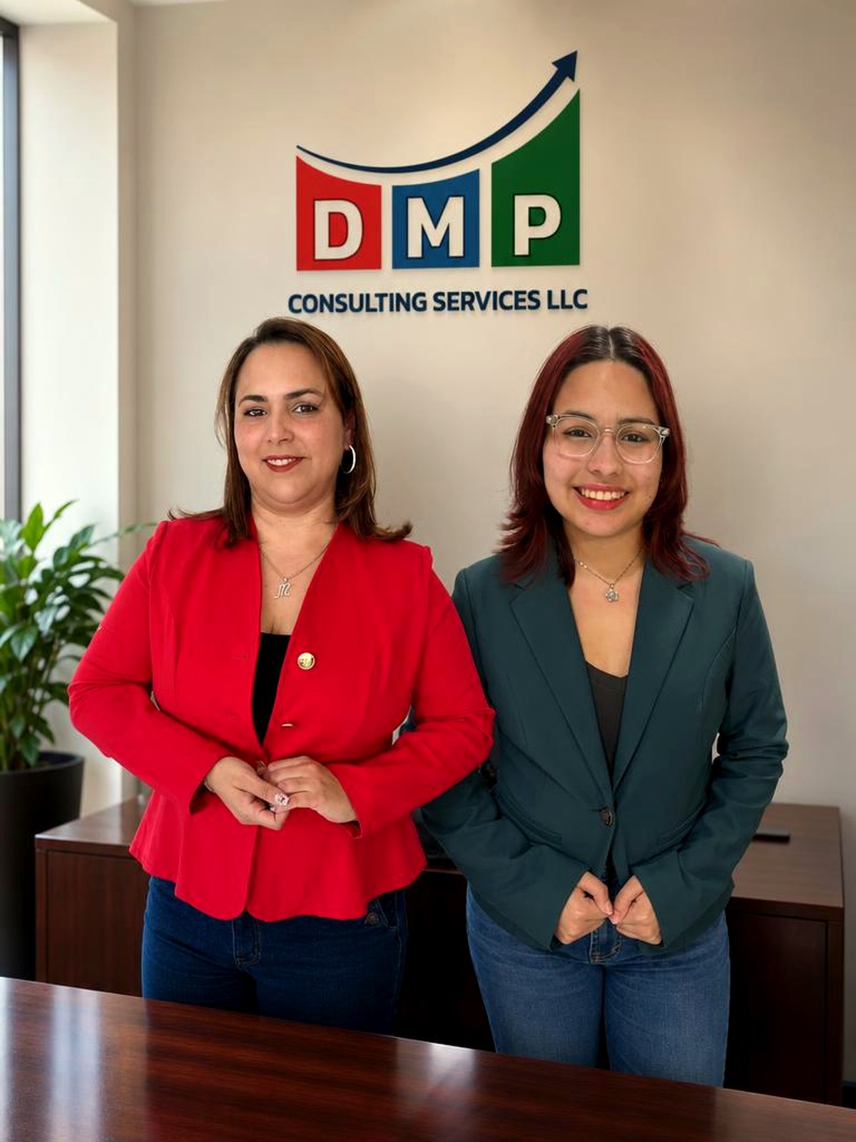 Mayli Parra y su socia frente al logo de DMP Consulting Services